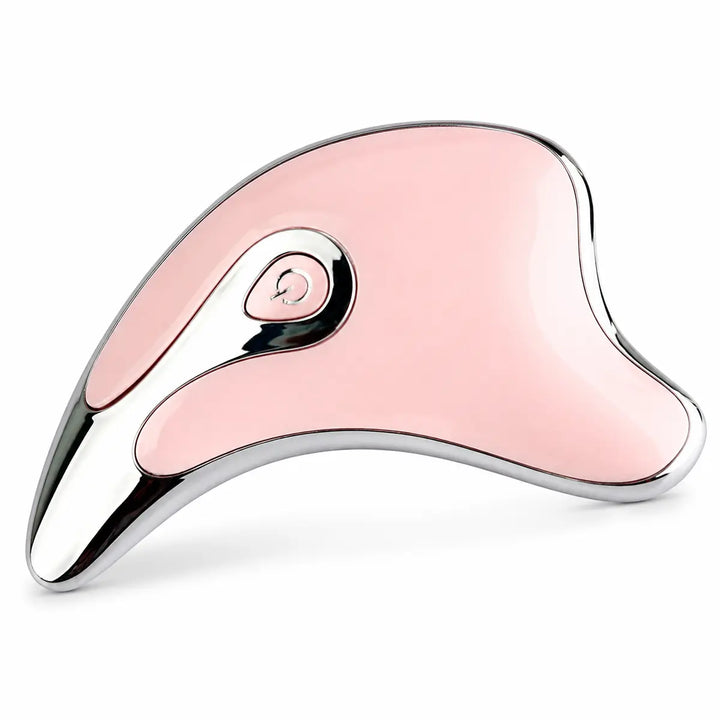 Pink electric gua sha massager in a low-angle detail view, highlighting the smooth surface, reflective trim and curved edges.