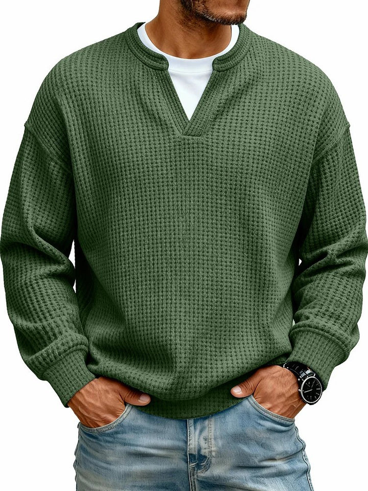 Green textured sweater worn by a person on a white background