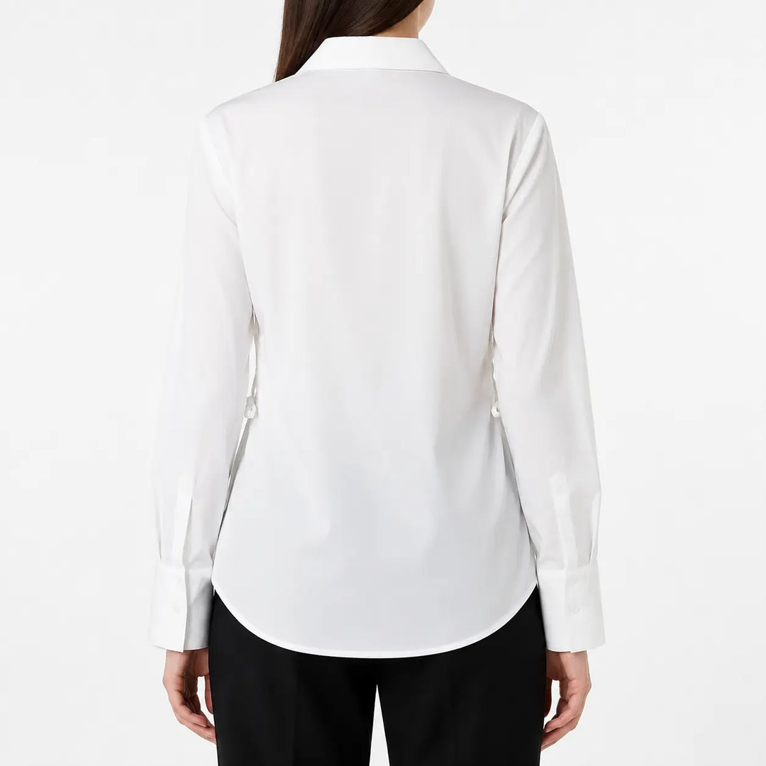 Back image of the white blouse on a female model, showing the plain rear panel, pointed collar, long sleeves, and curved hem.