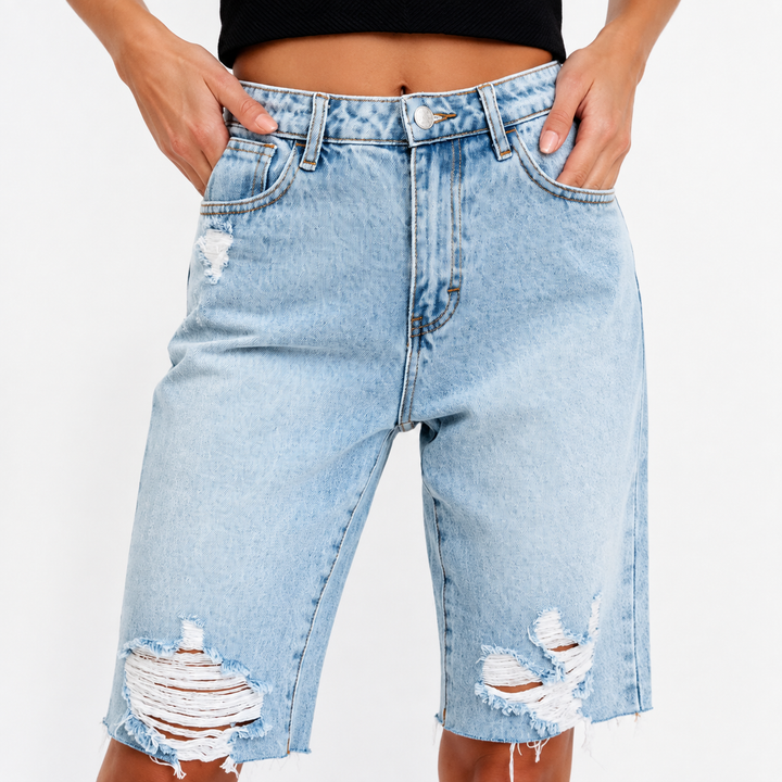 Close-up of high waist, button, zipper, pockets and stitching on blue denim shorts