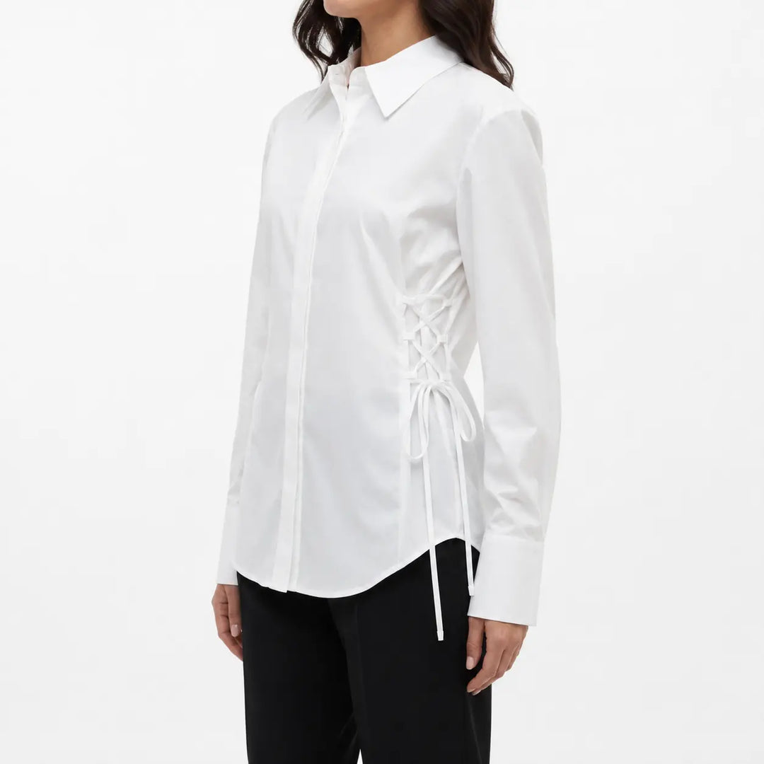 Three-quarter side fit view of the white blouse on a female fashion model, highlighting the lace-up waist and cuffed sleeves.