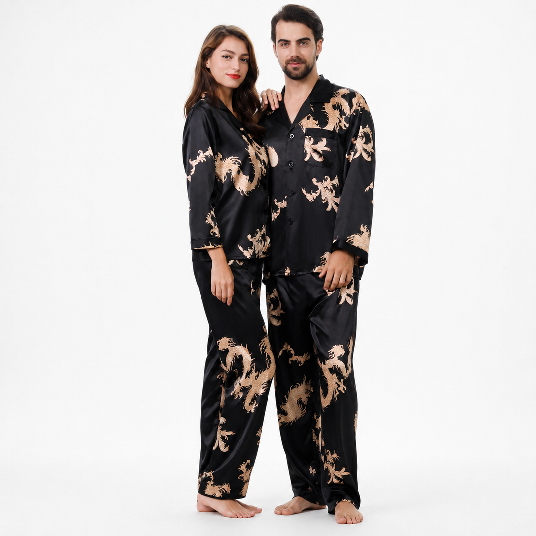 Classic black matching couple pajamas on a man and woman, with gold dragon and phoenix print, long sleeves and pants.