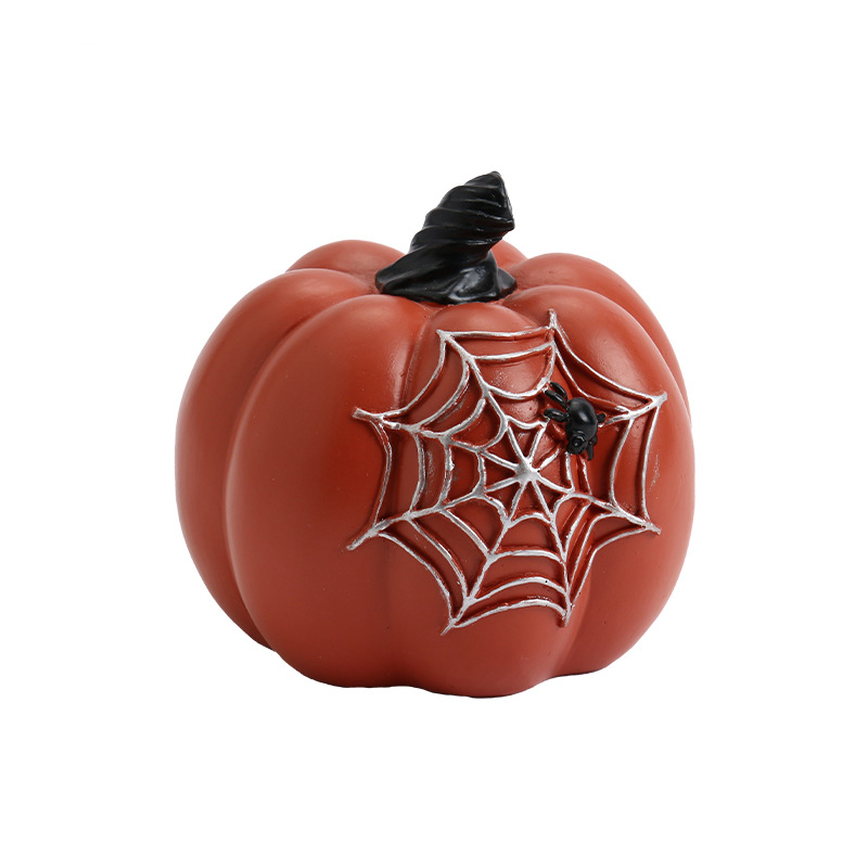 Reddish decorative pumpkin with a raised spider web, a little black spider and twisted dark stem shown on a white background.
