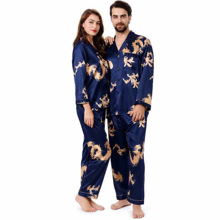 Royal blue matching couple pajamas on a man and woman, with gold dragon and phoenix print, long sleeves and coordinated pants.