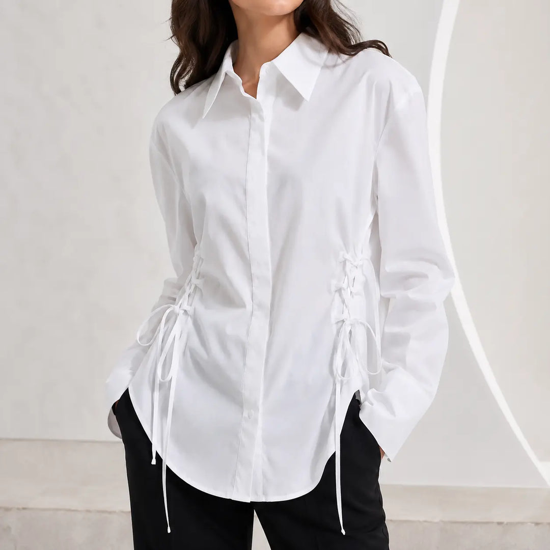 Commercial hero view of the white side-lace blouse on a female model, showing the pointed collar, curved hem, and waist ties.