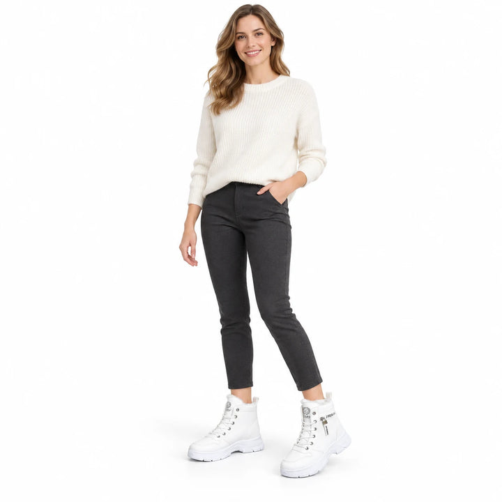 Woman wearing White lace-up ankle boots with an ivory sweater and dark trousers