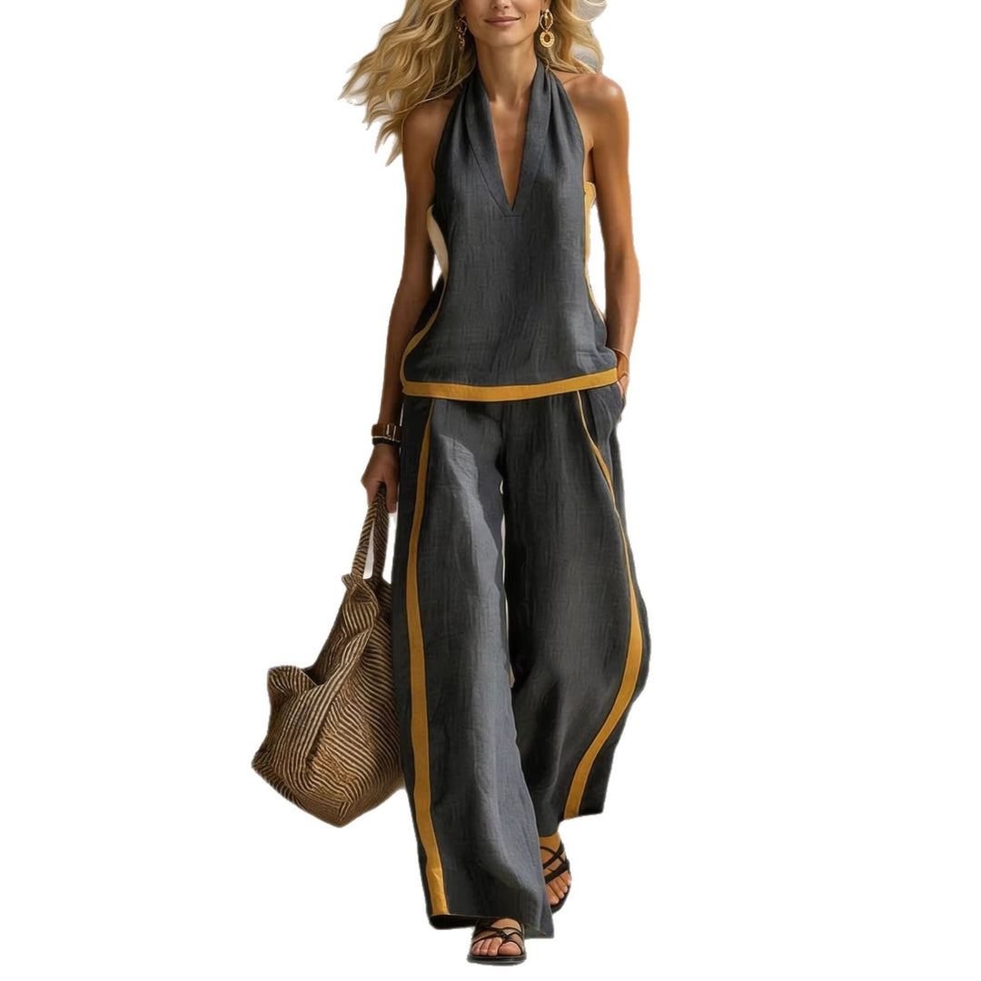 Woman wearing a gray jumpsuit with yellow accents, holding a woven bag on a white background