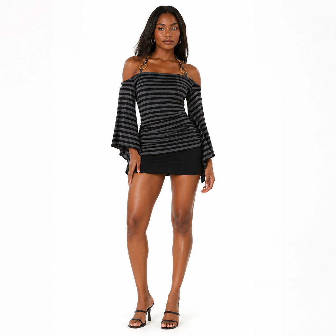 A woman modeling an off-the-shoulder mini dress with horizontal black and gray stripes, featuring long bell sleeves and a ruched bodice, paired with black strappy high-heeled sandals against a plain white background.