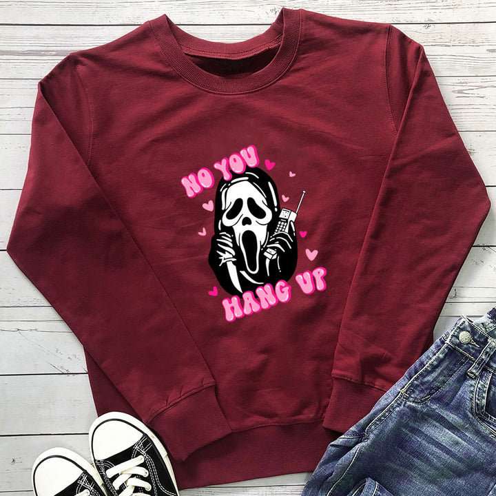 Original image: Burgundy printed crewneck sweatshirt laid flat beside a pair of jeans shown with the garment details visible.