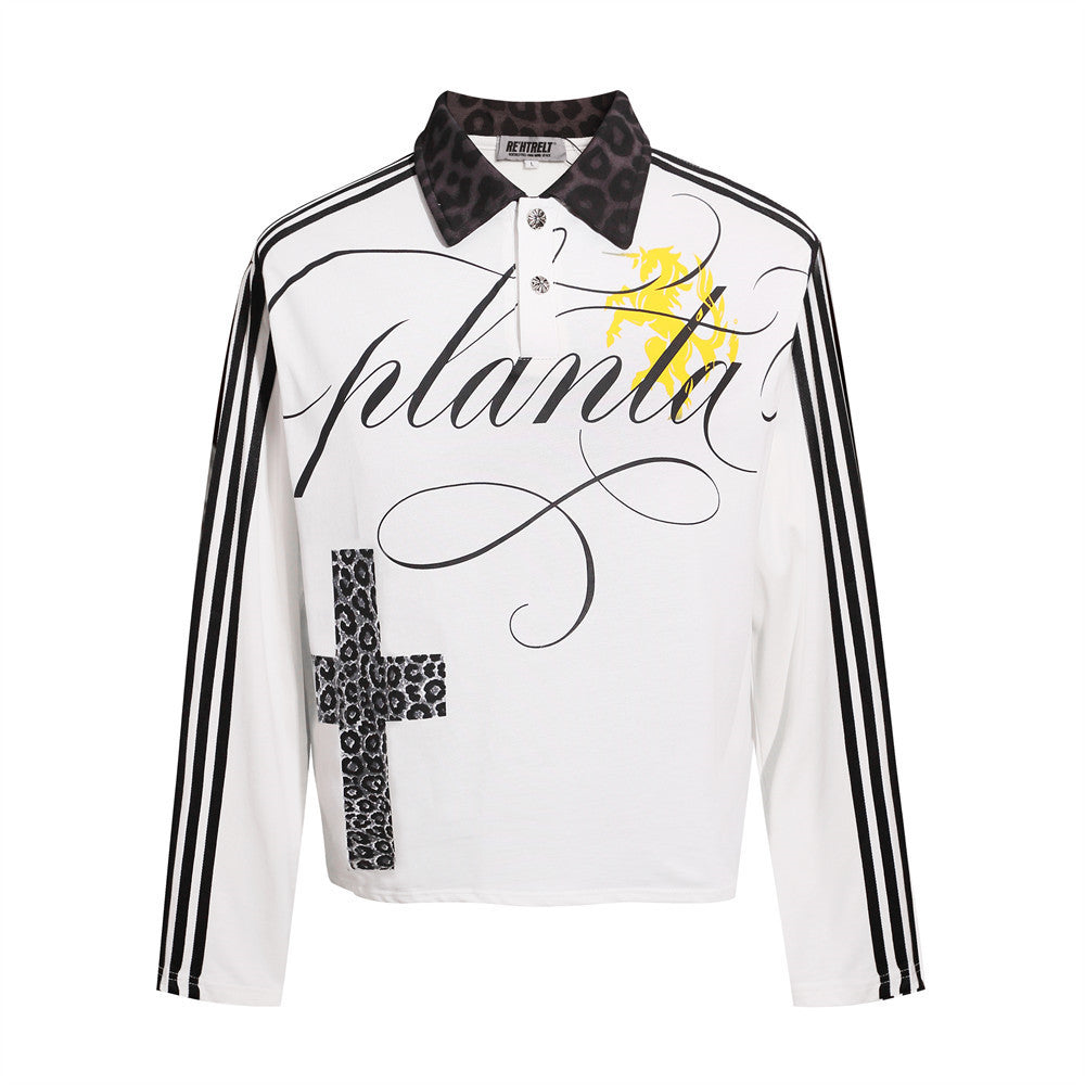 White gothic polo shirt, front view, with black sleeve stripes, leopard-pattern cross, black collar and a yellow chest motif.
