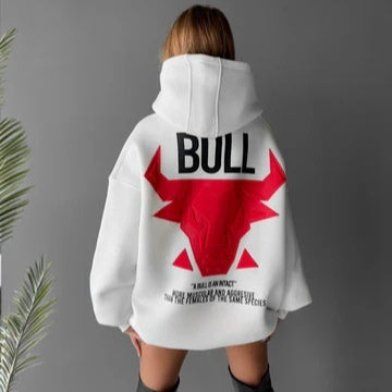 Rear model view of the white hooded sweatshirt with red bull artwork and black BULL lettering, styled against a grey backdrop