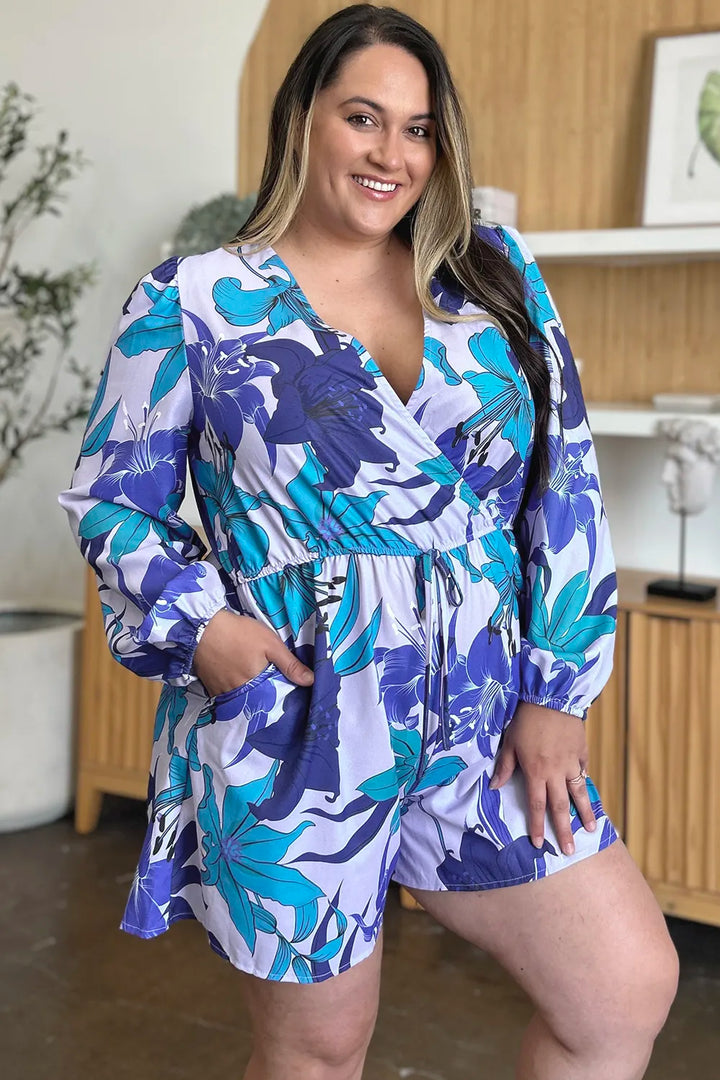 Floral romper in the Blue option showing long sleeves, pockets, 100% polyester and an opaque finish for a coordinated outfit.