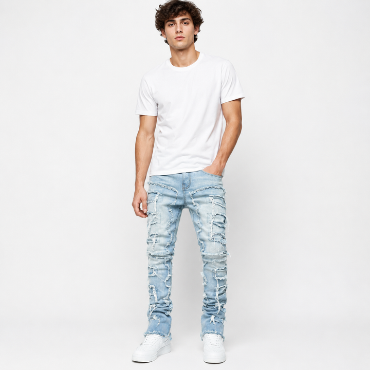 Mens stacked jeans with ripped fringe details and patchwork texture for a sharp streetwear look