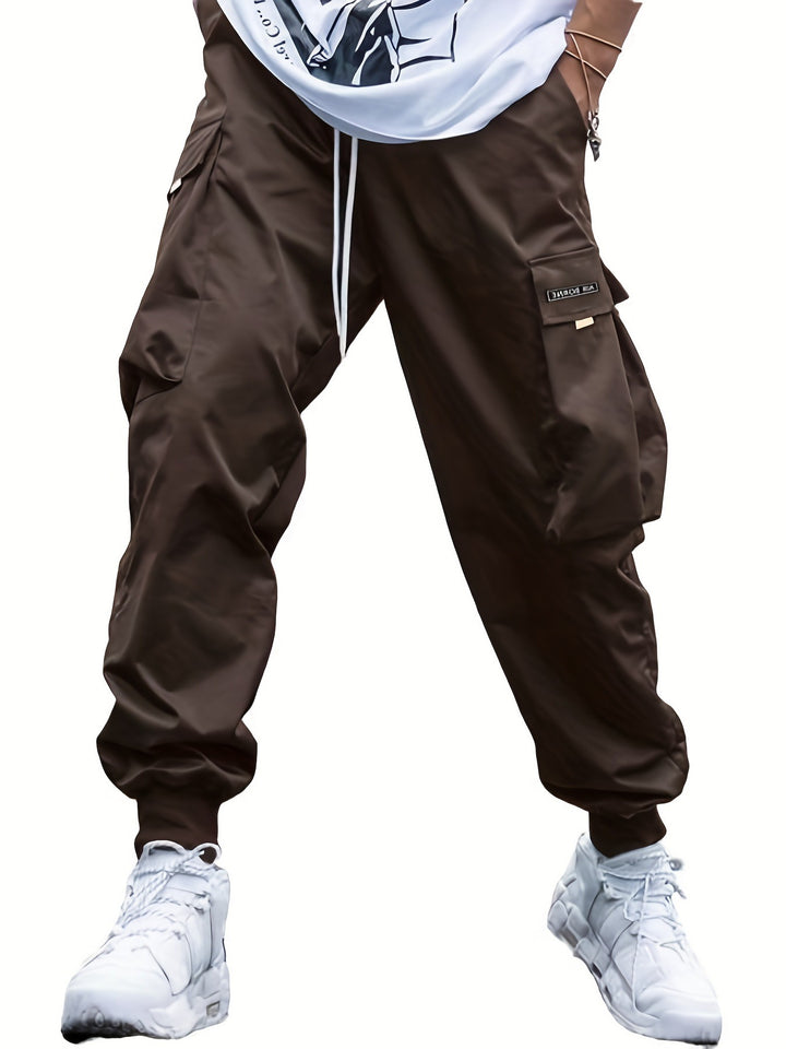 Brown cargo pants worn with a white shirt and white sneakers on a white background