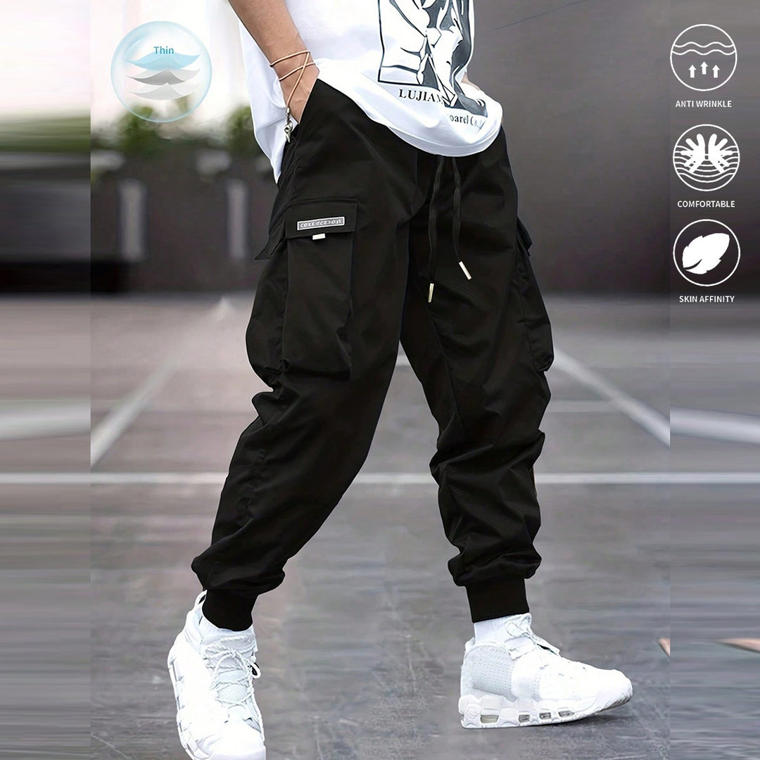 Person wearing black cargo pants and white sneakers on a blurred background