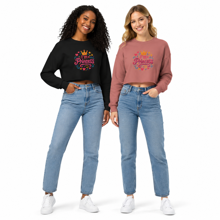 Two women modeling matching graphic sweatshirts and blue jeans against a plain white background. The woman on the left wears a black long-sleeve crop top with a colorful &