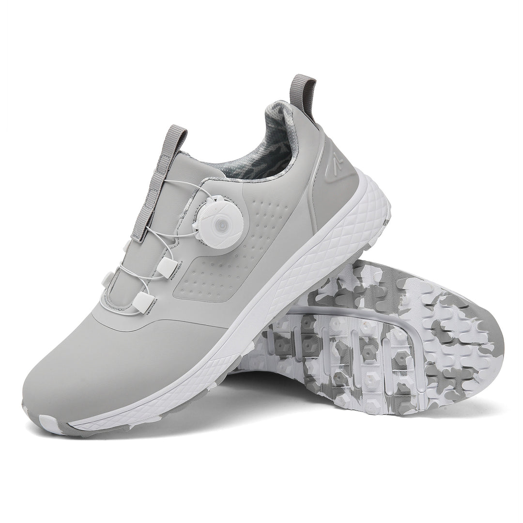 Gray rotary buckle footwear with a white dial and textured white midsole, next to a gray and white patterned studded outsole.