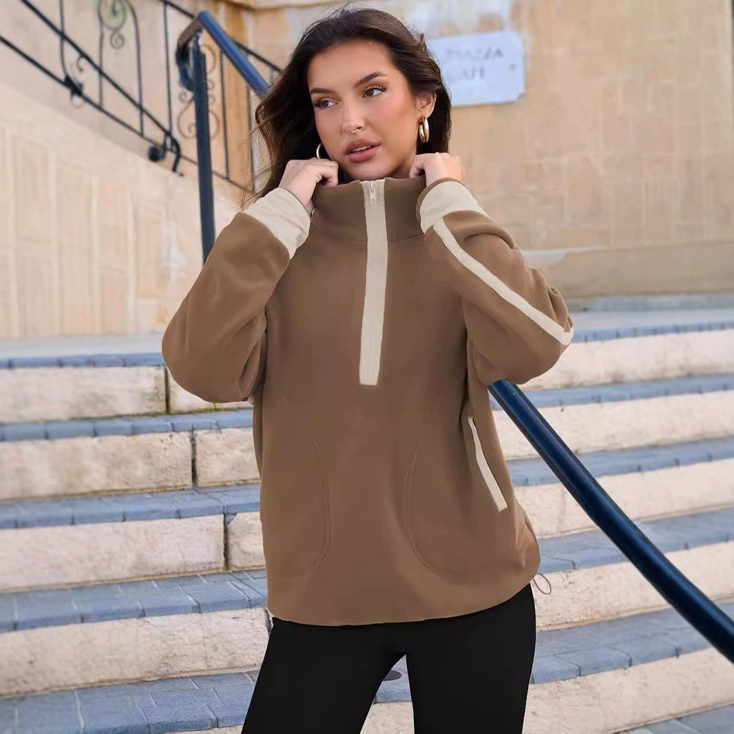 Woman wearing a brown hoodie with white accents on a staircase.