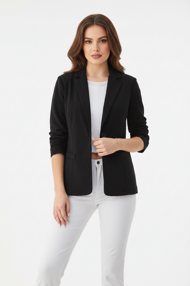 Woman wearing a black blazer over a white top and pants on a white background