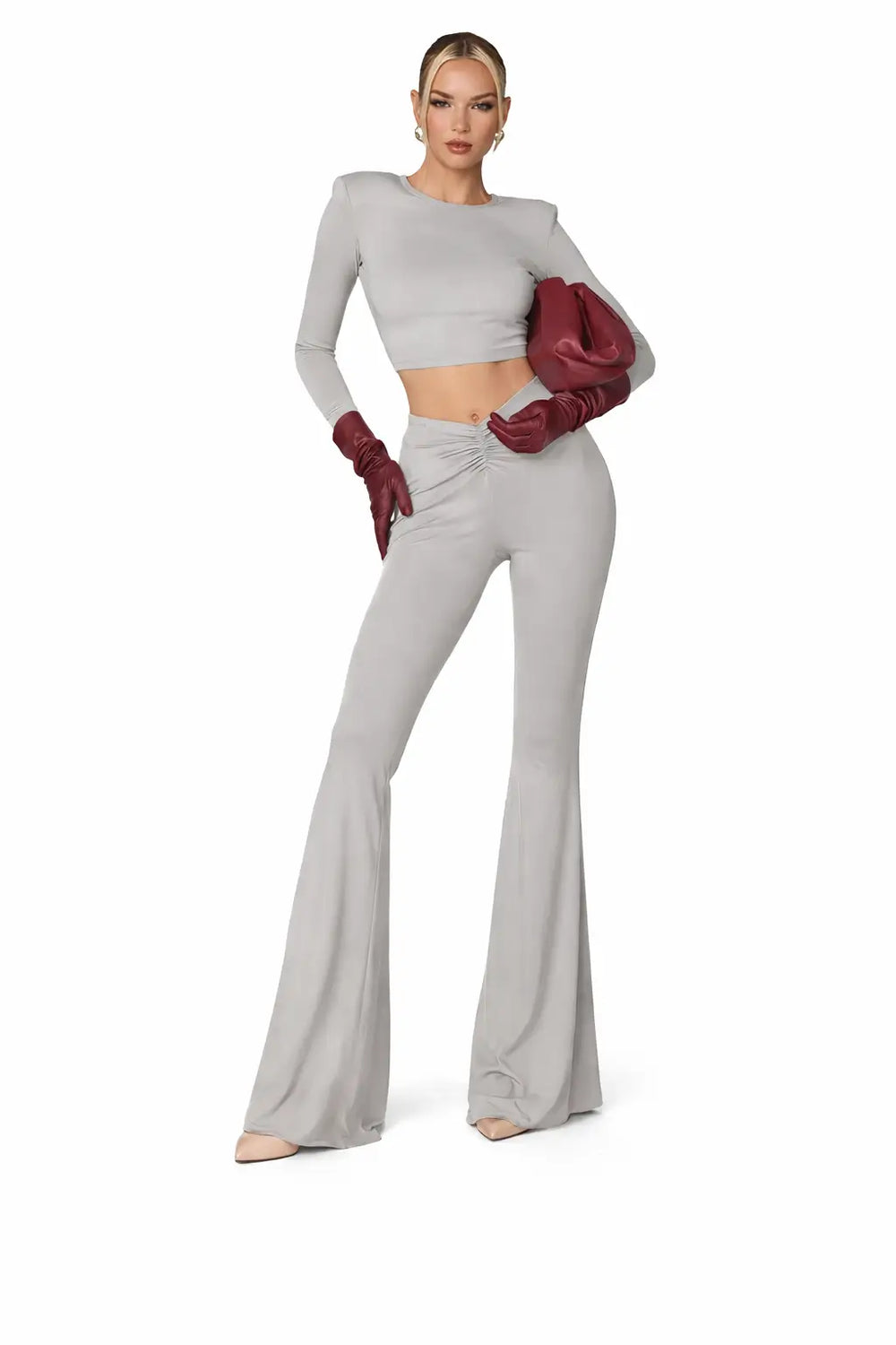 side profile view of gray pleated crop top and pants set highlighting exposed midriff and bell bottom flare for quiet luxury