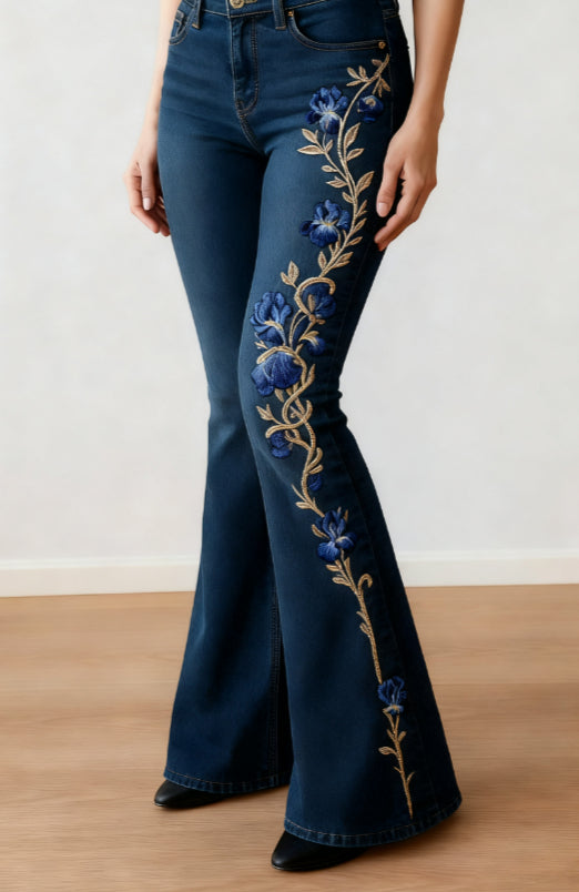 Dark blue flared jeans with blue flowers and a gold-tone vine print down one leg.