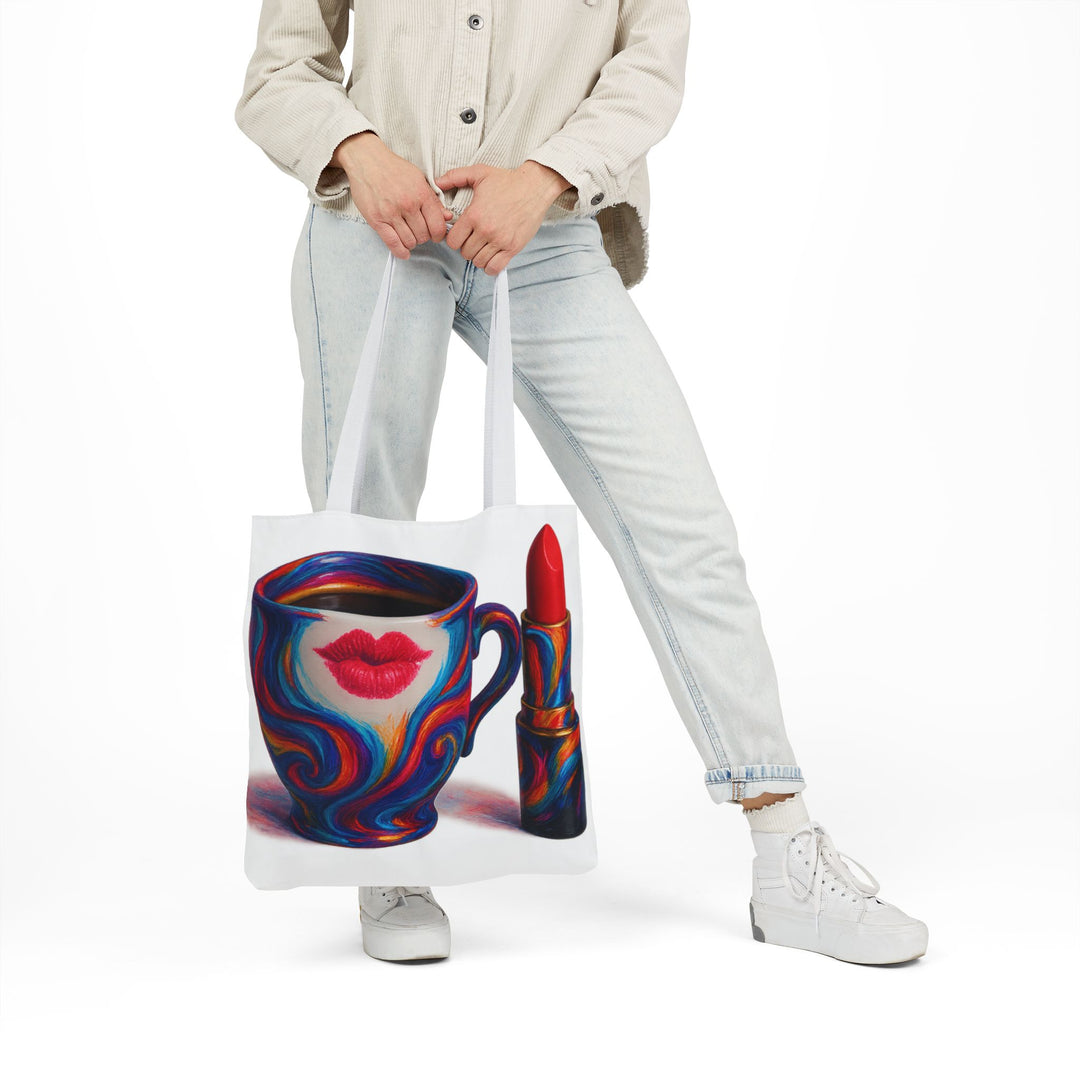 Person holding a tote bag with a colorful design of a coffee cup and lipstick.