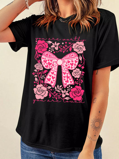 Valentines day t shirt floral design shown on hanger, close up of soft fabric texture and detailed bow print on front