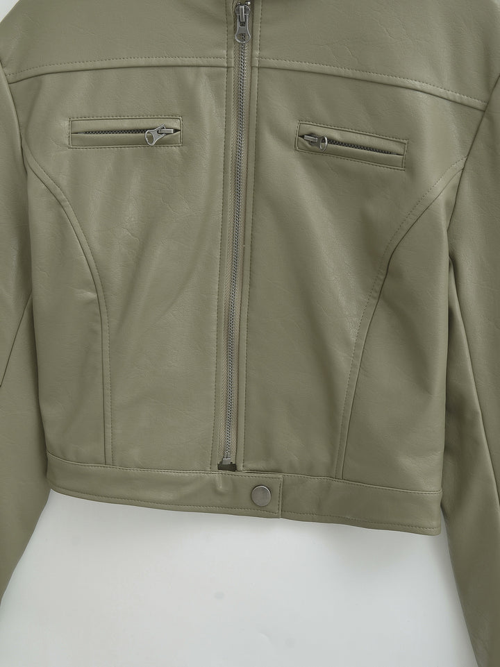 Gray Green jacket front close-up showing panel seams with chest zips, a center zipper and a studded cropped hem in the photo.
