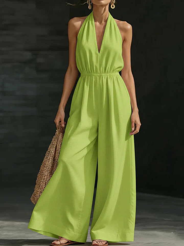 Woman wearing a bright green jumpsuit against a dark background