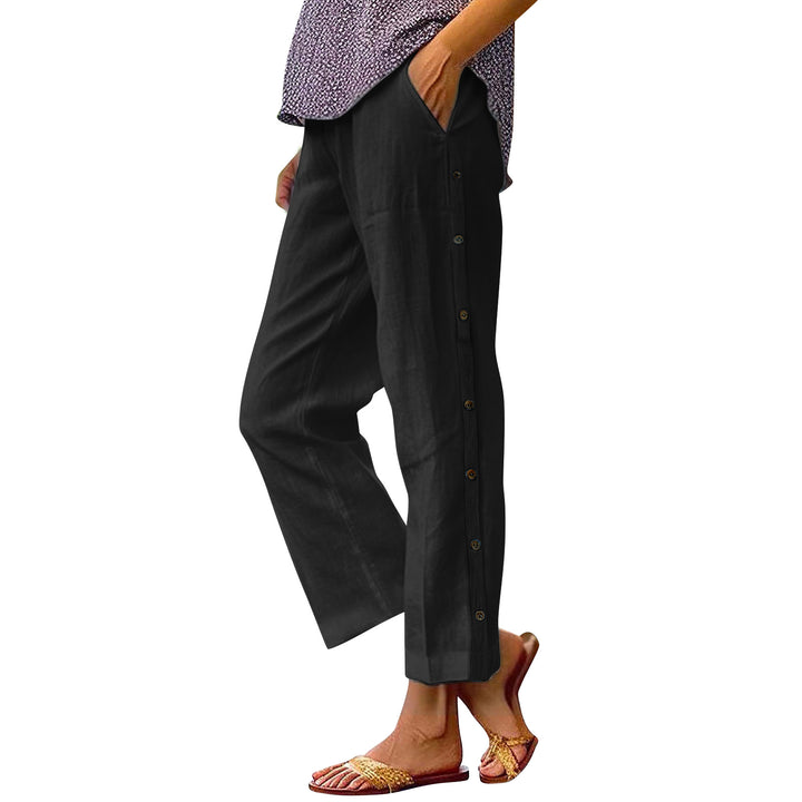 Person wearing black pants with buttons on a white background