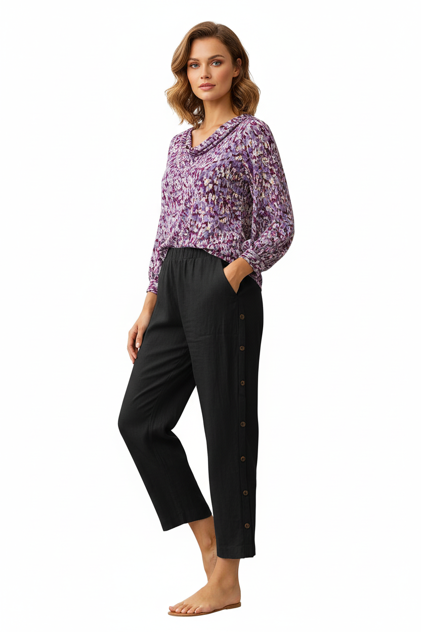 Woman wearing a purple floral blouse and black pants on a white background