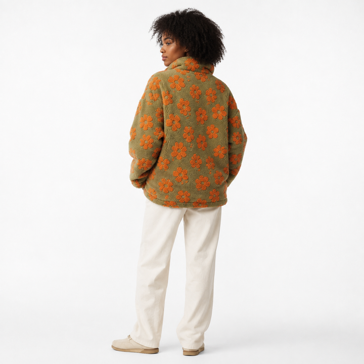 Oversized sherpa fleece pullover for women with floral print, cuffed sleeves, half-zip collar, and roomy front pocket design.
