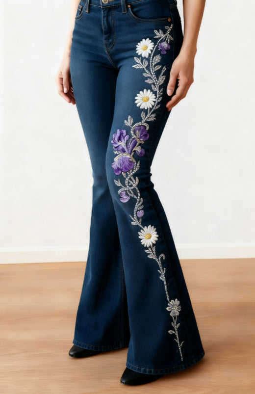 Dark blue floral flare jeans with purple irises, white daisies and grey vines printed down one leg.
