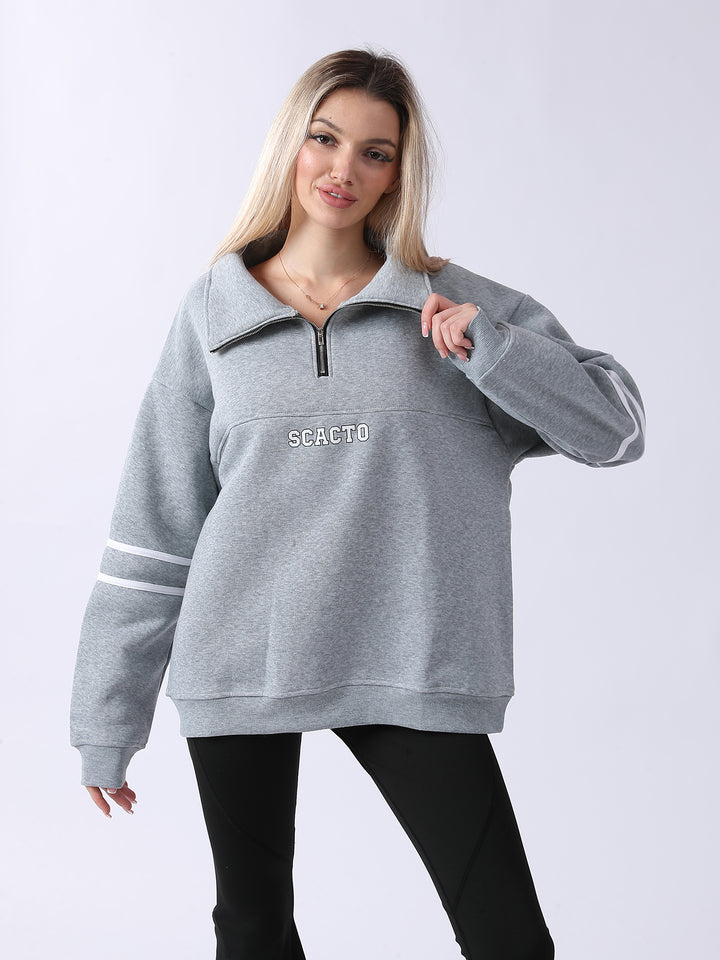Woman wearing a gray sweatshirt with &