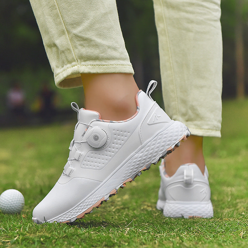 White and gray rotary buckle footwear worn with light trousers on grass, revealing the side dial, pull loop and white midsole