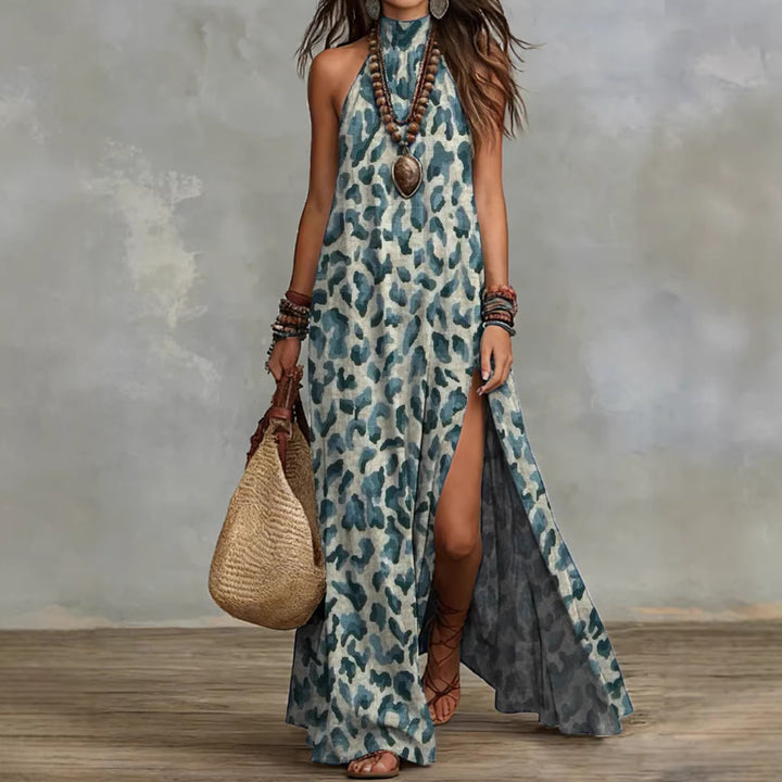 Teal printed halter maxi dress with sleeveless cut, flowing long skirt and boho accessories on clean white background