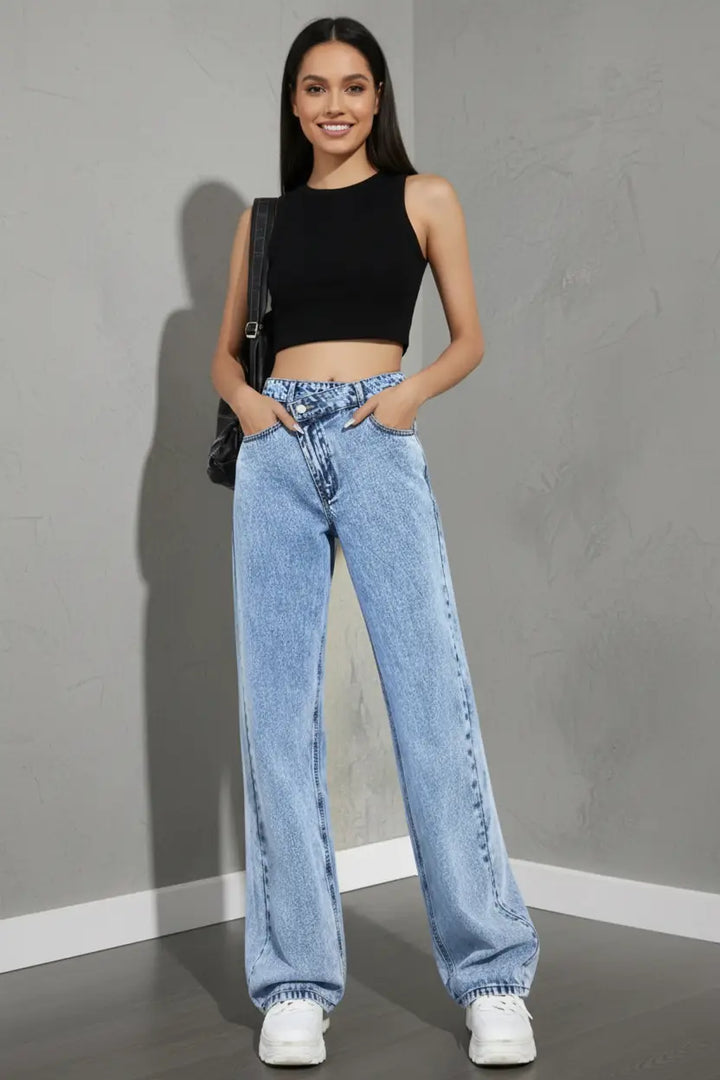 wide leg jeans for women high waist light wash denim relaxed fit side view with long hem pooling over white sneakers
