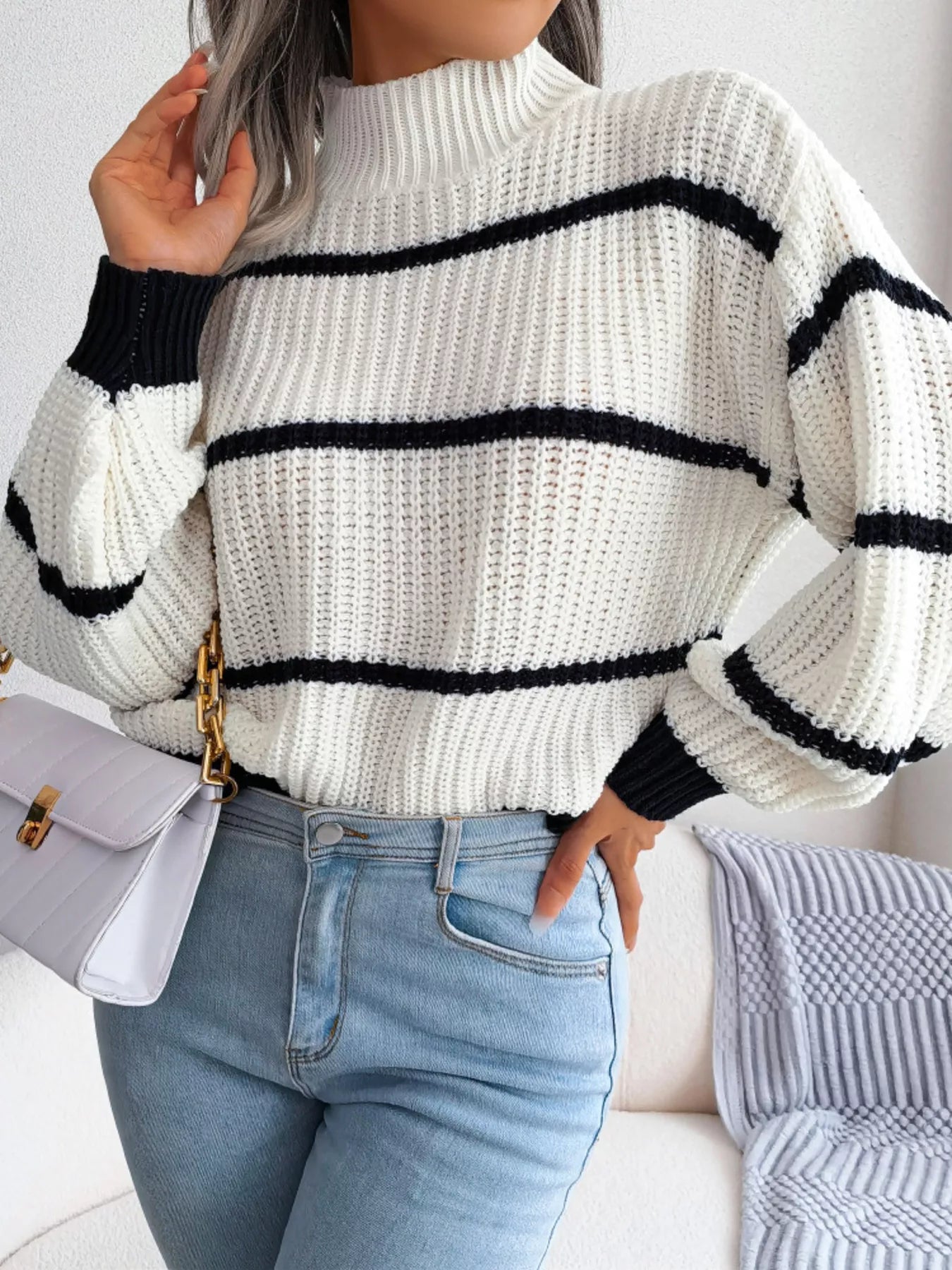 "ribbed plus size striped mock neck pullover sweater hanging on wooden hanger against wall in minimal closet"