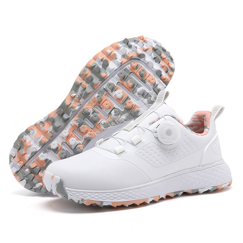 White and pink rotary buckle shoes with a coral, gray and white patterned outsole, shown beside an upturned shoe in a studio.
