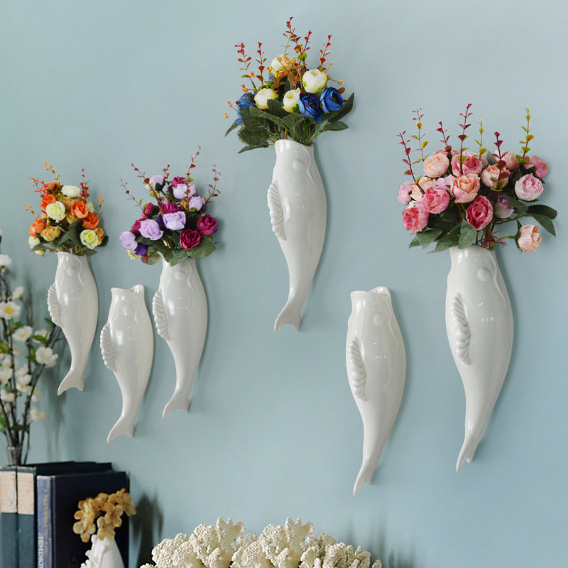 White ceramic wall vase with raised goldfish relief shown as decorative accent for living rooms, bedrooms and home entrances.