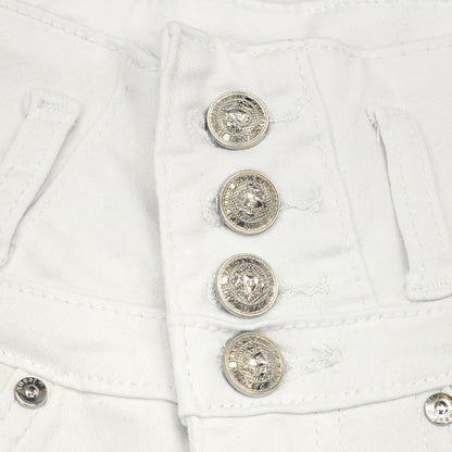 Detail view of rhinestone pocket and high-rise waistband of white shorts

