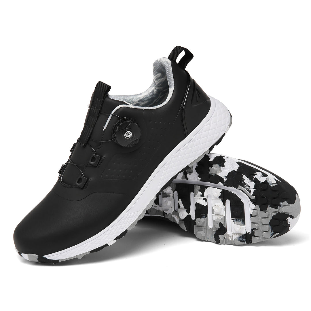 Black rotary buckle shoes with a white textured midsole and patterned black, gray and white studded sole on white background.
