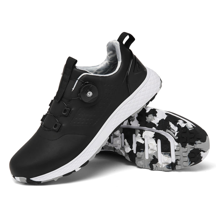 Black rotary buckle shoes with a white textured midsole and patterned black, gray and white studded sole on white background.