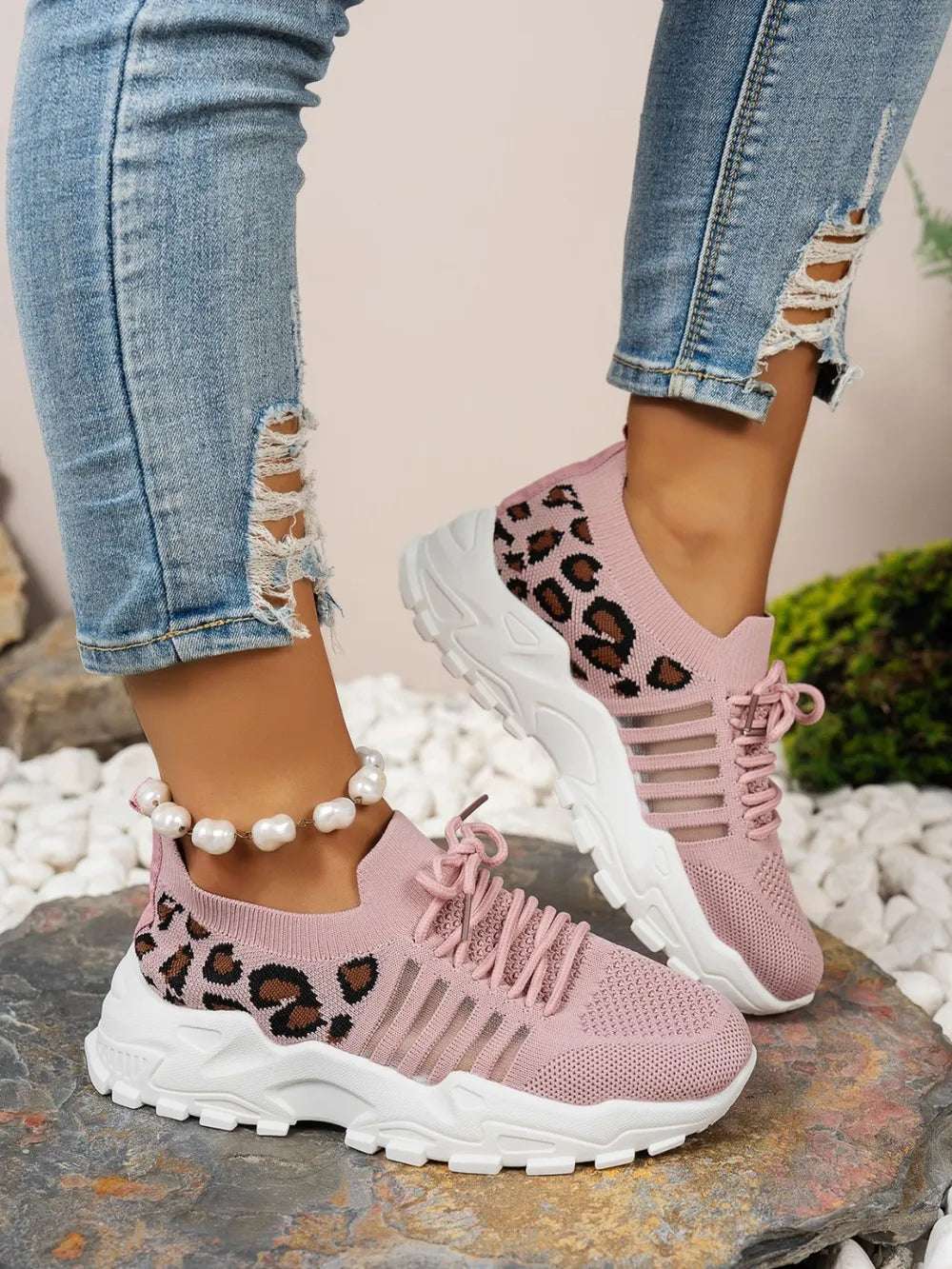 Leopard mesh sneakers next to fitness gear on wooden floor

