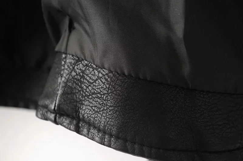 Close-up of the black jacket lining and inner hem band, showing stitching, the folded edge and the textured lower trim detail