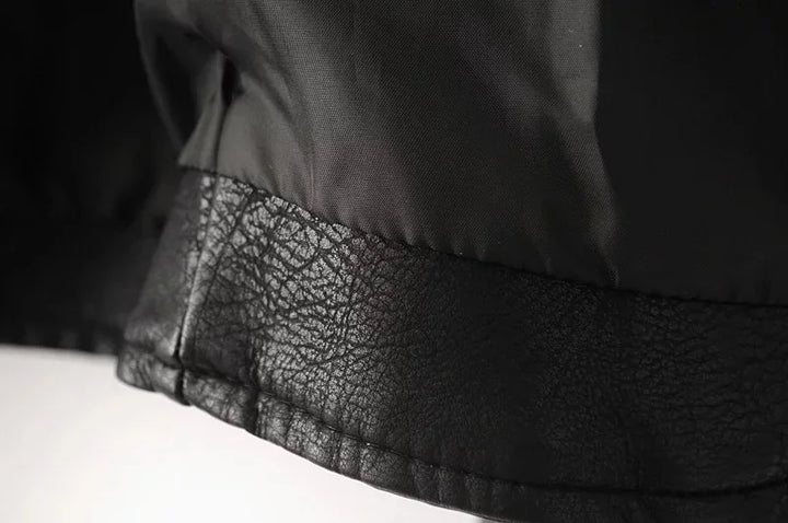 Close-up of the black jacket lining and inner hem band, showing stitching, the folded edge and the textured lower trim detail