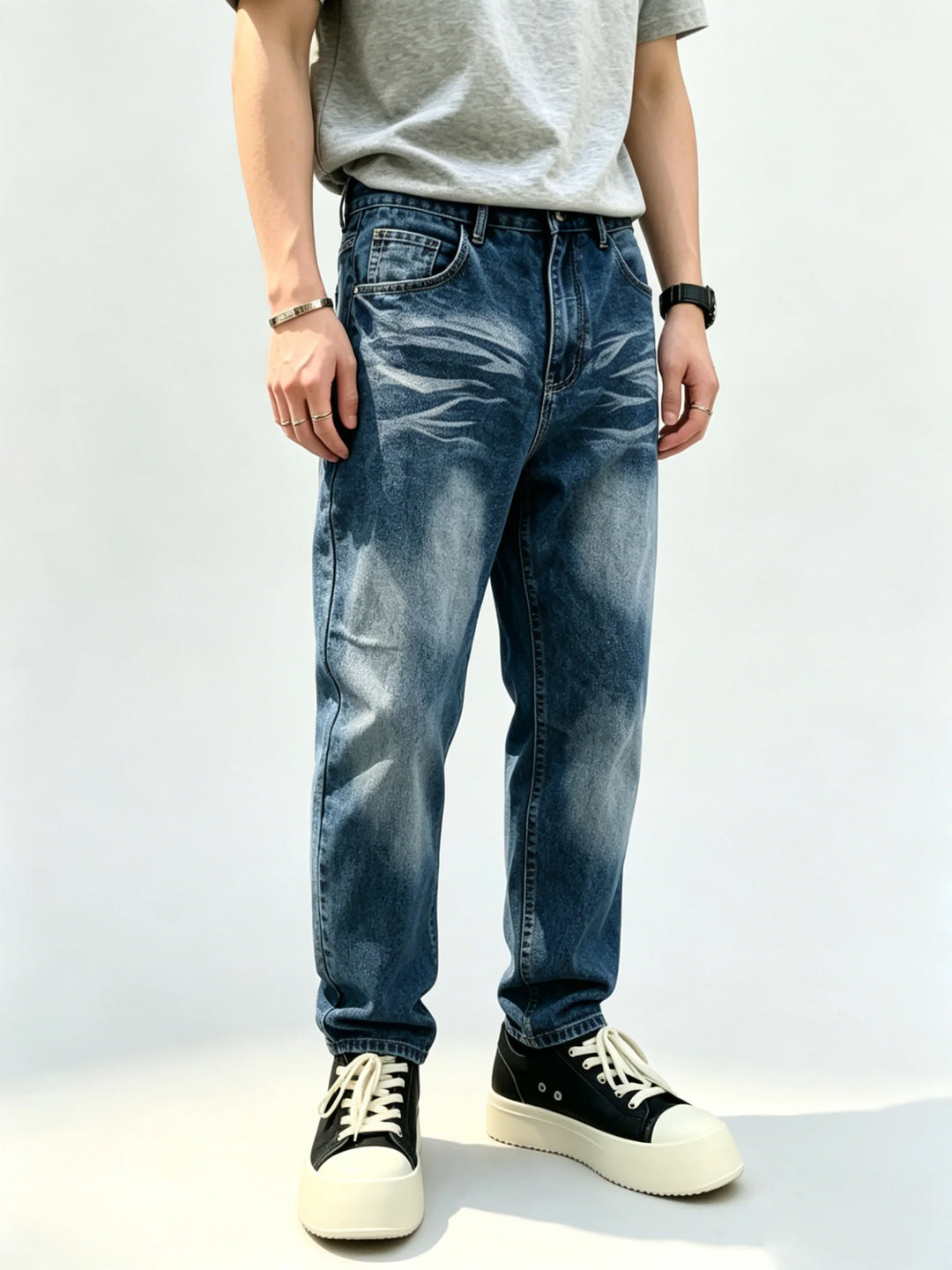 Blue vintage washed straight-leg jeans shown from the front on a model wearing a grey T-shirt and black canvas laced sneakers