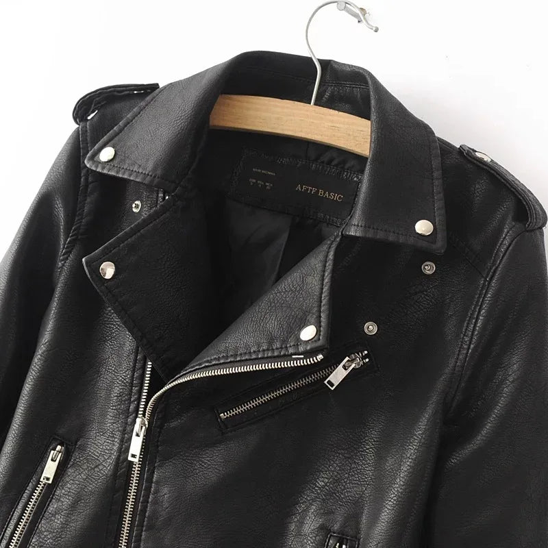 Close-up of the black jacket collar and shoulder, showing round snap details, an epaulet, surface texture and the angled zip.