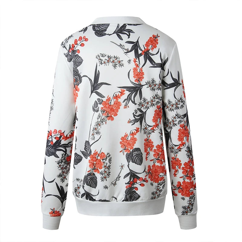 White botanical jacket back view on a white background with red blossoms, black leaf motifs and long sleeves with white trim.