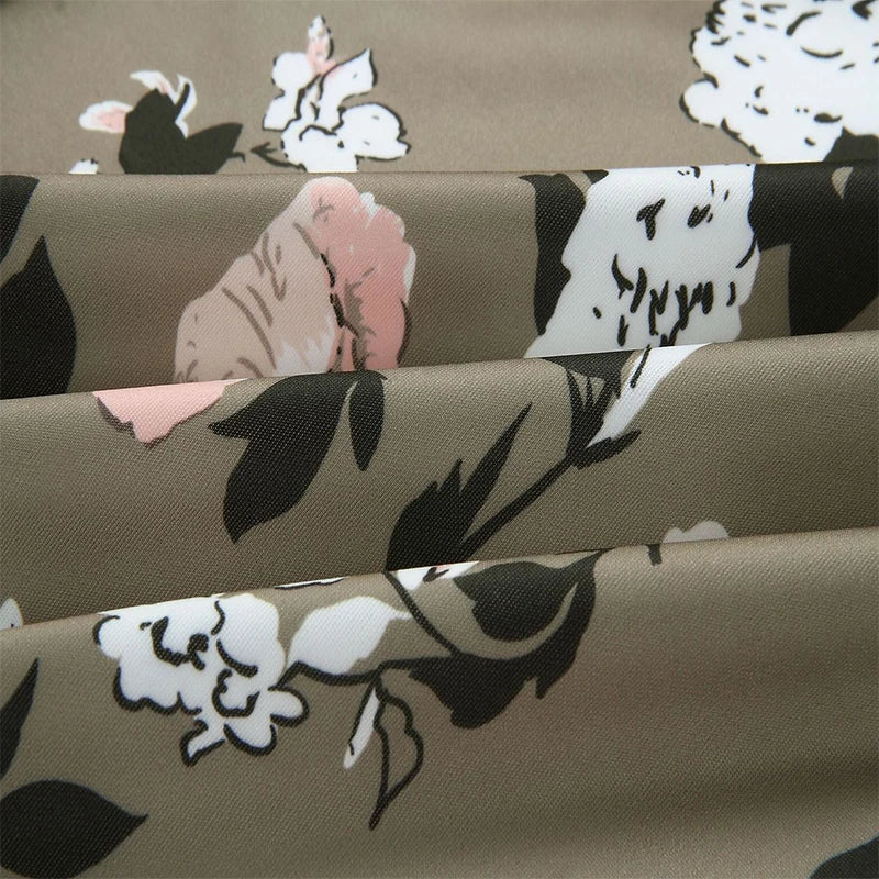 Close-up of Army Green patterned fabric, showing large white flowers, pale pink floral details and black leaves shown folded.